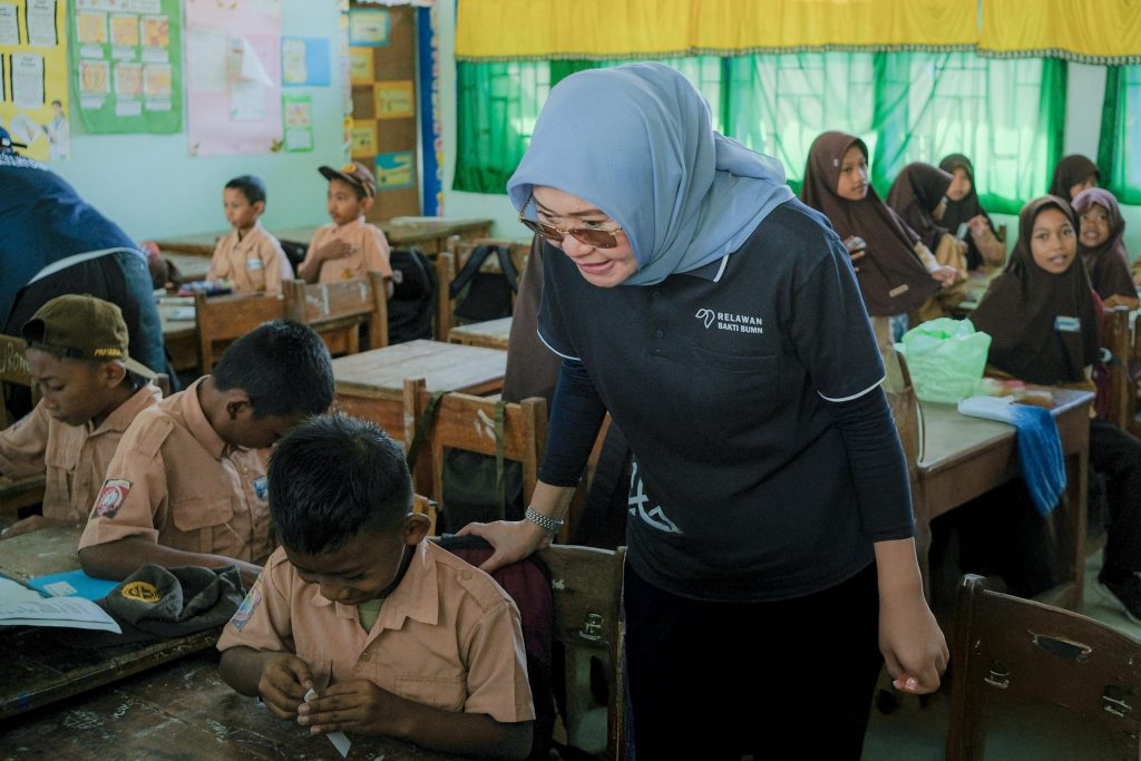 Dewi Aryani Suzana, Plt. Direktur Utama Jasa Raharja memperhatikan anak sekolah
